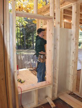 Openings in nonbearing walls are minimally framed, with single-member headers installed on the flat. The 1/2-inch plywood lining the rough opening extends out to cap the edge of the 4-inch-thick foam sheathing.