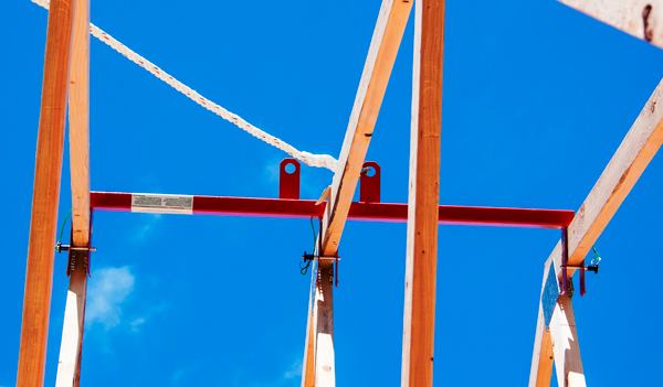 Anchor Point. The best way we’ve found to tie safety lines off when setting trusses is to use the 
Super Anchor Safety Bar. It is very easy to use and can provide fall protection for 2 workers. We used it on a remodel project last year where we had to remove the failing hand-built trusses from a car port. We just worked back from the gable setting the Safety Bar a few trusses in and moving it as we went.