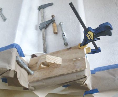 No-Mar Clamping Jig: This is about as basic as it gets — a scrap of plywood with a small triangular block attached that allows me to clamp the rail against the noses of the treads while I test-fit easings and locate newels.