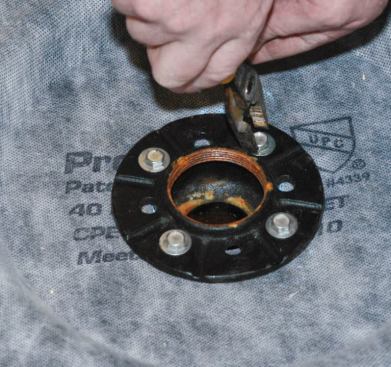 I bolted the clamp ring onto the drain upside-down, flat-side down, so that the sealant and membrane fabric wouldn't squeeze up into the drainage grooves as the sealant set.