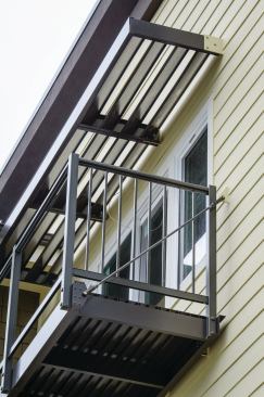 This lightweight, prefabricated aluminum balcony is designed with integral diagonal support rods that connect to brackets that are through-bolted to the house framing.