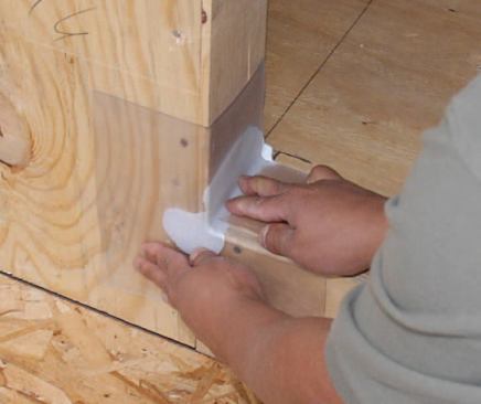 A pair of compatible flexible corner flashings set in beads of sealant are used in conjunction with 12-inch-wide peel-and-stick flashing.