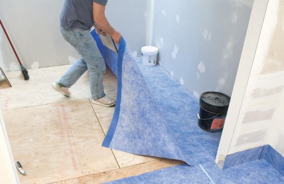 He secures the back of the sheet with weighted buckets, and lifts it out of the way.