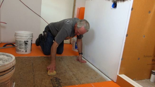 Step one for applying the underlayment is to thoroughly scrub the Advantech subfloor with a heavy-duty sponge. Otherwise, drywall dust and other dirt could interfere with the mortar bond between the Ditra and the subfloor.