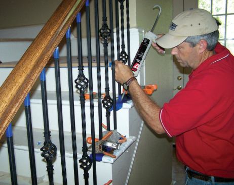 I lift each baluster up fully into its handrail hole, slide the shoe up away from the base, and inject the two smaller holes at the base of each baluster with enough epoxy to completely fill them.
