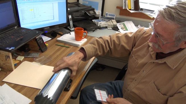 VerMod's Chet Pasho demonstrates how wall insulation core samples are weighed on a digital scale to ensure uniform density of the insulation application.