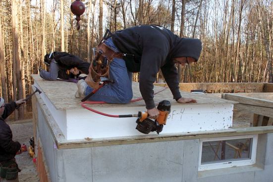 After the crane drops four 8-by-24-foot 12-inch-thick floor panels into position, the perimeters are nailed to the pressure-treated sill.