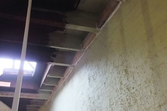 A view of the existing roof framing of the hundred-year-old Brooklyn row house, including modifications implemented as part of the current project. The building’s floor and roof framing has been reinforced in places with LVL, steel, or parallam members, and visible in this view is solid blocking installed between roof joists as nailing for the ProClima Intello smart vapor control membrane and for ceiling drywall. Blocking is caulked to the ceiling framing and the wall in order to help maintain a robust air barrier, or “air control layer.”