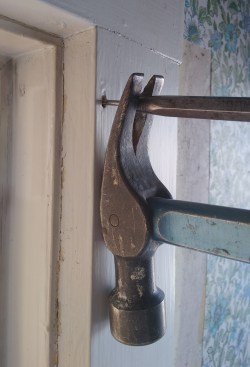 Often it just needs to be loosened, after which it can be pulled out by hand. If the nail is small enough, though, you will be driving the pin through fresh wood and it will need to be pried all the way out. In this case, use a block under the hammer to keep from bending the pin and to protect the face of the board.