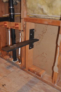 The wall-hung vanity is supported by steel brackets bolted to wall framing (IronSupports.com makes left- and right-hand versions of the brackets).