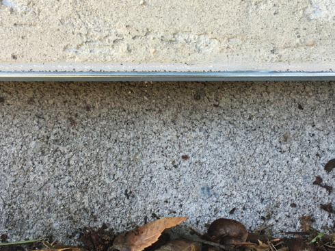 Above is a grade-level view of plywood and stucco with weep screed overhanging a slab footing. Looks tight, right?