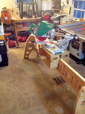 The author cut handholds in the saddle box to make it easier to lift the miter saw on and off the Tri-horse rail.