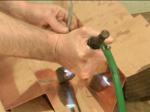 Then “tack” the seam in several places with a spot of solder. This keeps the two pieces of copper in close contact with each other so that they will heat up evenly. Soldering is two-handed work: one hand works the iron, the other controls the solder stick.