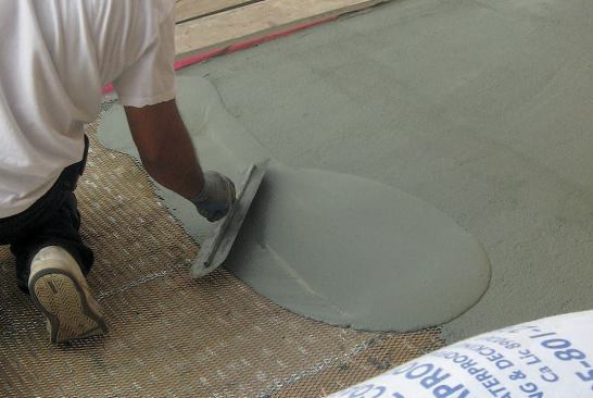 Polymer cement is troweled over the lath.