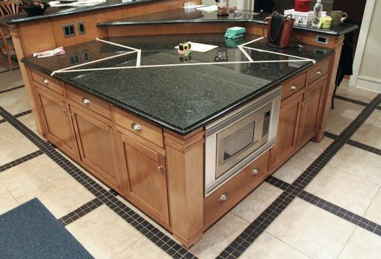 We experimented with the shape of the new island, putting masking tape across the counter so the home owner could visualize the results and we could be sure there was enough depth to reinstall the microwave.