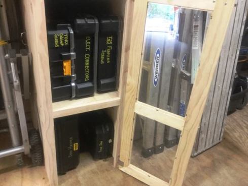 A demo hammer and recip saw store in boxes below; the upper shelf houses DeWalt Deep Pro organizers containing removable bins of electrical connectors and screws. The organizers are modular and can be clipped one to another and carried by a single handle. The wheel on the left is from a Bosch Gravity Rise Stand and table saw.