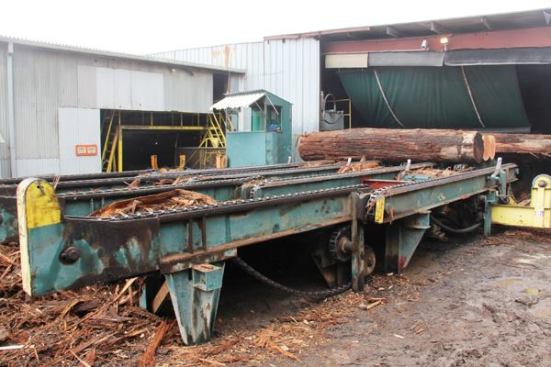 Logs enter the mill via a platform called the live deck—live because of a chain-drive mechanism that allows it to move and sort logs (
video here). The operator stands at a control panel inside the shed and by moving the chains one direction or the other is able to position logs so they can fed into one of two openings in the wall of the mill. Each opening leads to a different saw; one set up for quick cutting of low-value logs and the other set up for careful milling of high-value logs.