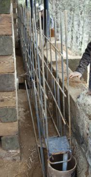 Tube forms surround the upper ends of the piers, to encase them in concrete.