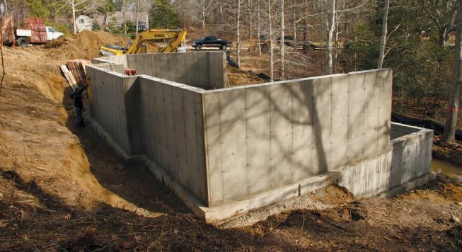 The authors installed drain tile, which outlets to daylight around the completed foundation. Note the standing water just inside the silt fence.