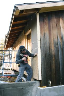 A layer of sheathing over new exterior foam insulation flattens the walls and simplifies flashing and siding installation.