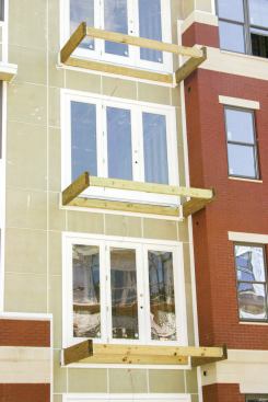 Instead of a system of cantilevered joists connected to the interior floor framing, these balconies are framed with pairs of cantilevered LVL beams.