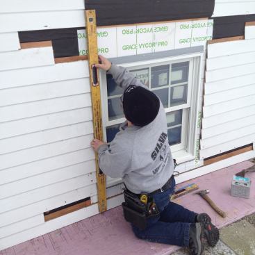 A level set against the side jamb of the window ensures that it's plumb in the opening.