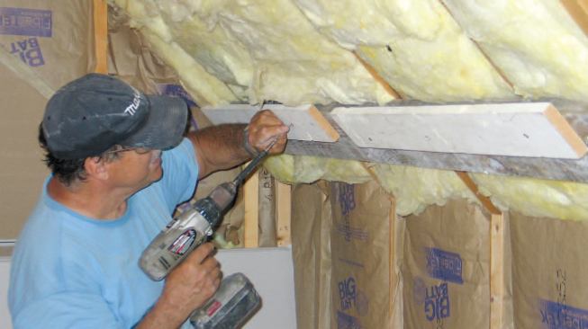 Before installing drywall on a sloped ceiling, the author fastens a simple cleat made from scrap lumber to the framing about 483/8 inches below the wall/ceiling junction.