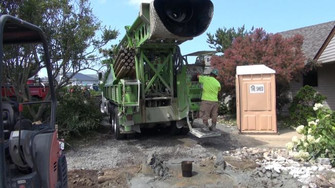 After completing the final well shaft, the crew pulls its drill truck away from the well, in preparation for inserting the geothermal ground loop tubing.