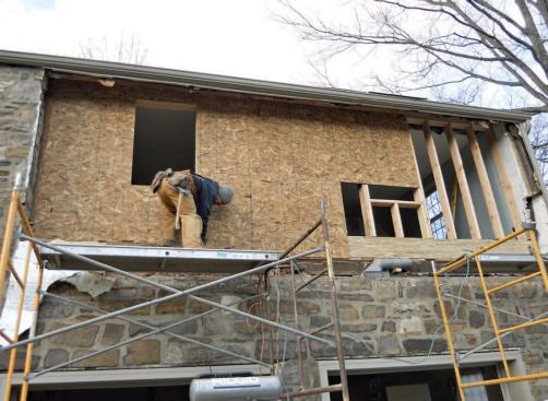 The face of the sheathing is 1 1/2 inches behind the back of the stone to allow for drainage.