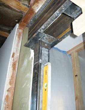 Two 4x4 steel columns bolted to brackets welded to the girder above provide support.
