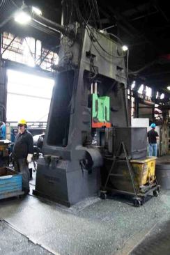 A massive die-forging machine used to form pliers parts out of a yellow-hot billet of steel.