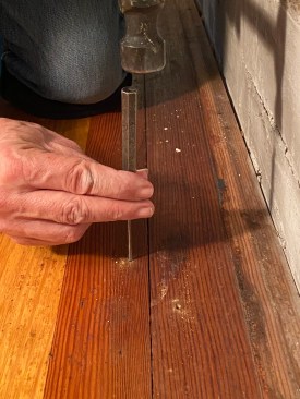 Installers face-nailed the last floor boards. This is the side to start with.