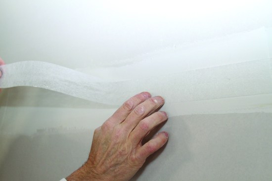 Fiberglass-mat tape gets placed into joint compound the same way as paper tape. It is easier to embed with a knife after placement because the mat is porous.