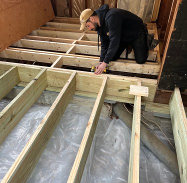 The old porch floor, which had been completely demolished, was reframed with pressure-treated material.