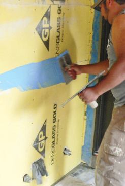 The blue membrane is troweled onto seams and joints.