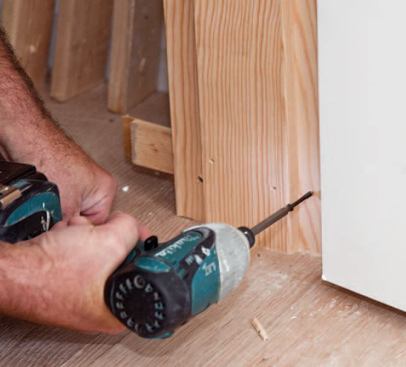 Discrepancies in the reveal between door and jamb are addressed with additional shims, followed by jamb screws.