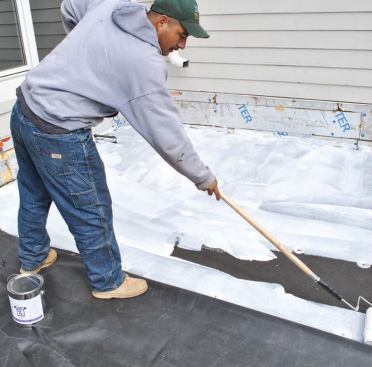 The membrane is folded back on itself so it can be glued down a section at a time.