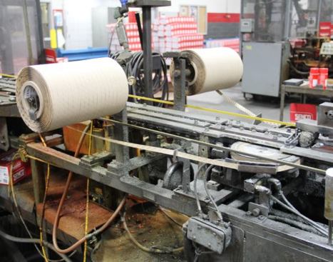 The paper tape on these rolls will be glued to the sides of the clipped-head nails in the machine, turning them into strips that will fit 34-degree framing guns. 
Click here for video.
