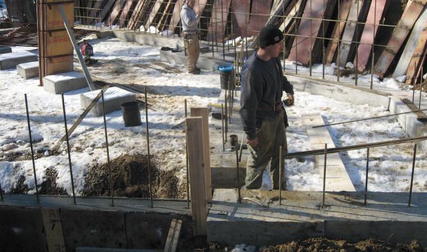 For the 10-inch-thick foundation walls, the engineer specified a grid of #5 rebar. The footings step down 5 feet on the walk-in side of the foundation. Because this portion of the wall is not subject to soil pressure, its thickness is reduced to 8 inches.