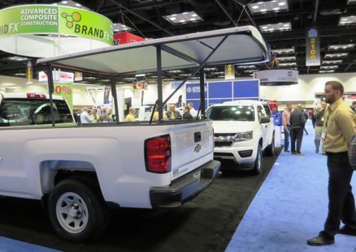 BrandFX makes composite truck bodies and this BFX Easy Lift, a tonneau cover that pivots up on a pair of arms with gas cylinder assists. When open, it provides shade for anyone standing behind the tailgate. When closed it provides security. If you need to haul a load that won’t fit under it when closed, you can drive with it open at up to 75 mph. The cover weighs about 180 pounds and sells for about $2,600. 
Click here for video of it being operated.