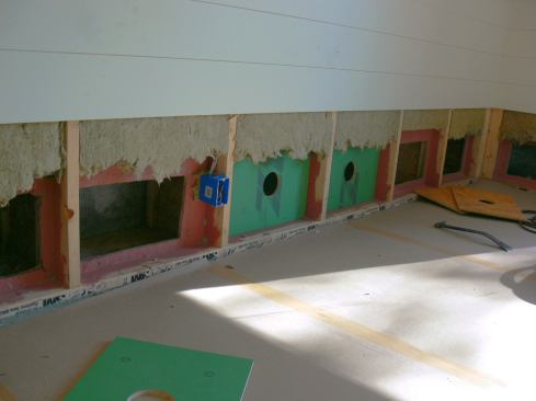 Here's a look at ZIP sheathing patches applied to repair holes in the OSB air control layer. The round holes in the center of the patches will allow fresh dry cellulose insulation to be dense-blown into the cavities.