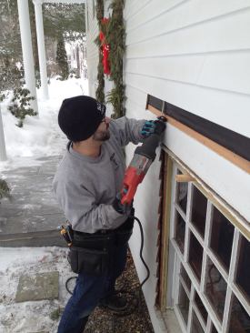 Manny peels back the siding above the window and then clips the siding nails with a reciprocating saw. Note that he leaves the siding along the sides of the window intact.
