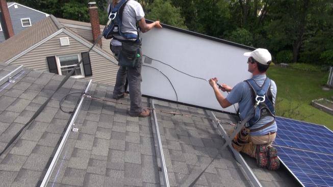 With the connection made between the solar array’s home-run cabling and the wiring that will bring the DC current to the inverter, Bernard and Janarelli begin setting panels on the mounting rails. As each new module is added to the string, they connect it to the last module using the plug-in connections preinstalled on each module.