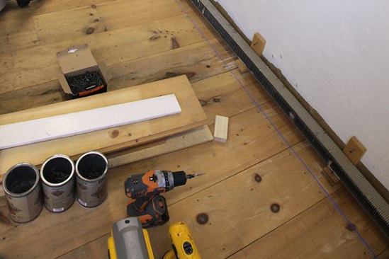Before laying out the 2-foot centers for the base blocks, we snapped a chalk line on the floor. Because the barn walls were so wavy, we let the brackets set the actual distance from the wall.