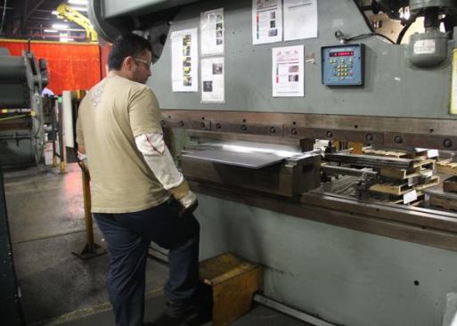 This older hydraulic press brake is manually controlled and requires a human operator. The pieces it’s making are small so it’s no big deal for the operator to lift them.