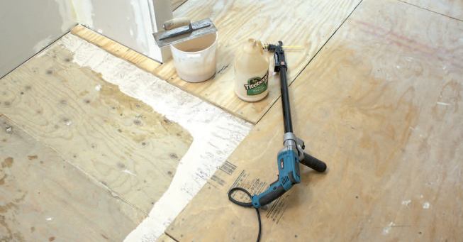 The plywood underlayment is partially installed. Note that glue was spread a few inches beyond the footprint of the plywood sheets. As subsequent boards are secured, any exposed glue not covered within five minutes or so should be removed with a scraper and damp sponge.