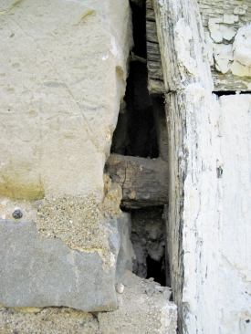 Where the stone got in the way, the original carpenters cut off the ears and inserted wood pegs for keying the bucks to the masonry.
