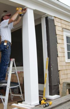 The purely decorative columns were fitted together — cap, column, base — then slid into place under the beam; here, after securing the cap, the author screws the side of the column to the alignment block inside.