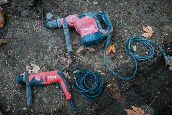 We keep a couple of Hilti rotary hammers for drilling concrete, the 
TE 2-S and TE 76P (since replaced by the 
TE 70). Whether we need to drill for wedge anchors, threaded rod, or just a post base, we drill into concrete on every house. We get the most use out of the smaller TE2 as it is capable of making the holes we need in the relatively green concrete we usually encounter. Our typical anchor and threaded rod holes are 5/8 or 3/4 inch in diameter and seven to 10 inches deep. We keep the TE76 around for when we need to make holes larger than 1 inch such as when we drill a 3-inch hole through a concrete patio or stem wall to connect a downspout.