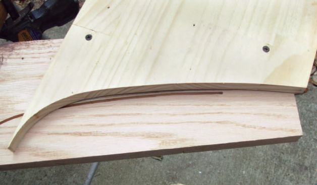 Rout the Return: I slide the pattern along the pencil mark so that it makes a smooth transition, reattach it with the screws, and finish the cut.